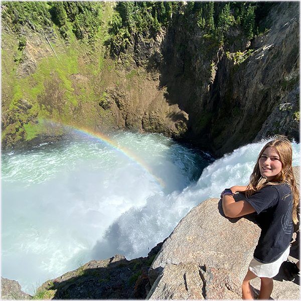 YellowstoneTourBrinkofLowerFalls Guides of Jackson Hole a girl standing at the Brink of the Lower Falls lookout in Yellowstone National park